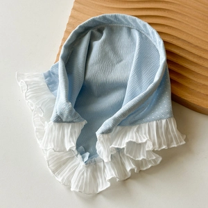 Détail du tissu à pois bleu clair avec bordure en dentelle de mousseline plissée