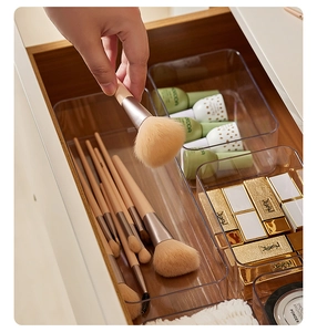 Close-up of clear plastic drawer organizers holding several makeup brushes in a neat layout