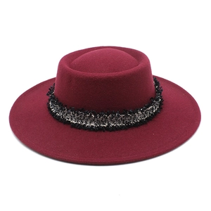 Detalle del sombrero de lana burdeos con cinta de tweed blanco y negro y bordes deshilachados