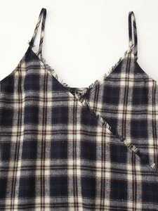 Detail of blue plaid top featuring a V-neckline with frayed fringe edges and thin straps