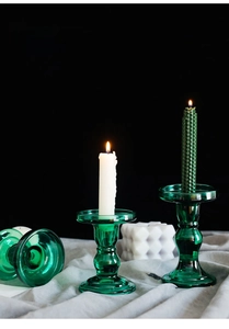Detail of green glass candle holders in vintage pillar style with honeycomb candles