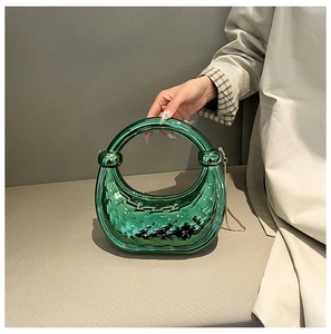 Green metallic acrylic handbag featuring a woven texture and knot handle on model