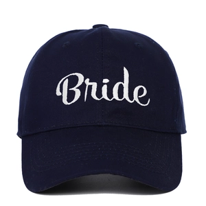 Detailed close-up of white cursive Bride embroidery on a navy blue cotton baseball cap