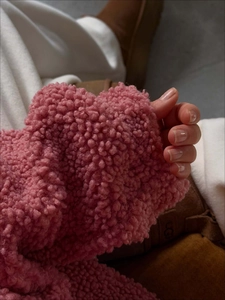 Close-up of soft pink sherpa fleece texture on a loose half-zip sweatshirt sleeve