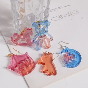 Detail of colorful resin earrings in horse, bear, and castle shapes with jelly texture