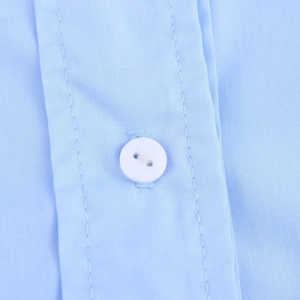 Détail de chemise bleu clair avec des boutons blancs et des coutures doubles