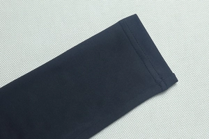 Détail de la couture à double aiguille et texture du tissu sur le poignet en maille