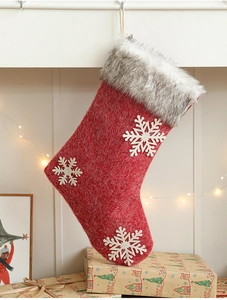 Detailed view of red Christmas stocking with snowflake applique and grey faux fur cuff