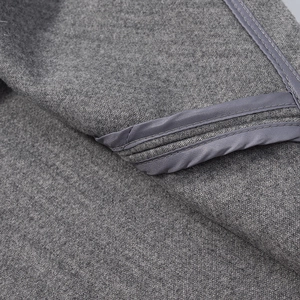 Detailed close-up of dark grey wool fabric texture and high-quality stitched hemline