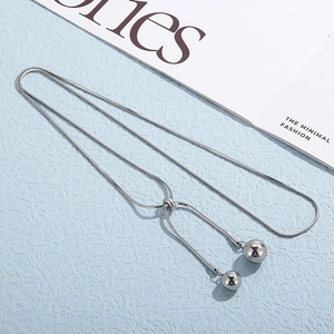 Detailed view of adjustable silver snake chain necklace with dual metal bead pendants