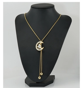 Detailed view of long gold celestial necklace with moon and star pendant on mannequin