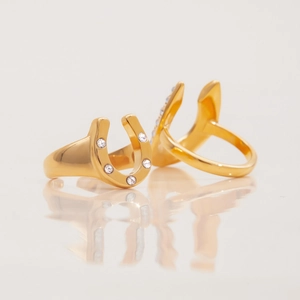 Detailed view of two 18K gold-plated horseshoe U-shaped rings with white zircon stones