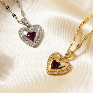 Detailed macro view of heart-shaped ruby pendant with zircon halo on champagne silk