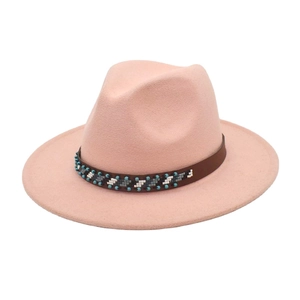 Détail du chapeau fedora en laine rose avec bande en cuir et motif perlé ethnique