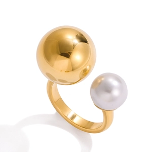 Minimalist open ring featuring a polished gold sphere and a white pearl on a white background