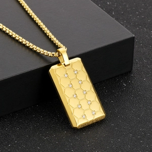 Gros plan du collier en titane doré avec pendentif à motif hexagonal serti de diamants
