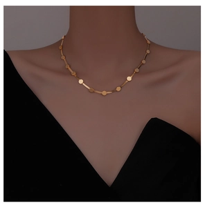 Close-up of golden flat snake bone choker necklace with round sequins on a female model