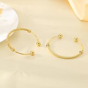 Detail view of 18K gold plated mesh twist cuff bracelet with smooth spherical ends