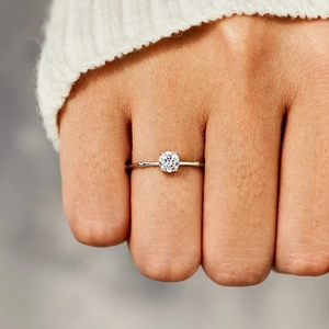 Minimalist s925 sterling silver ring with single round cut stone on a female hand