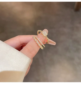 Detail of gold double-layer rings set with cubic zirconia teardrop and square crystals