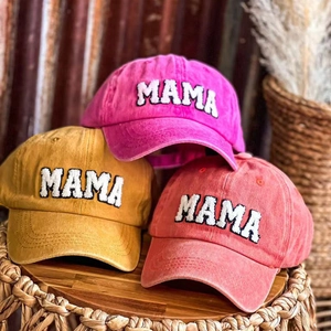 Detail of embroidered MAMA patches on vintage washed cotton baseball caps in multiple colors