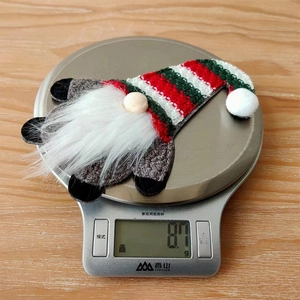 Close-up of a Christmas gnome cutlery holder being weighed on a scale at 8.7g