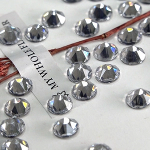 Detailed macro view of sparkling silver round faceted glass rhinestones on white background
