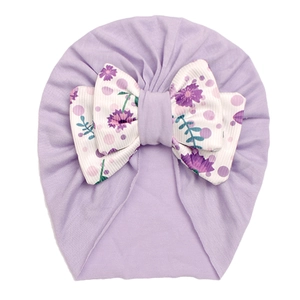 Detail of baby turban featuring light purple fabric and a floral print knot bow