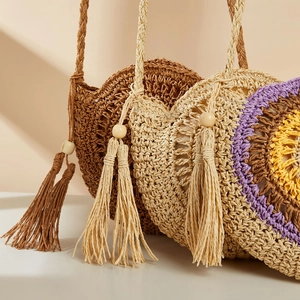 Detailed texture of round straw shoulder bag with wooden beads and large tassels decoration