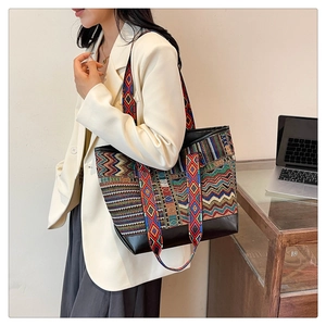 Detail of ethnic style tote bag featuring colorful geometric patterns and black leather trim