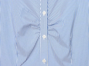 Detail of blue and white vertical striped women's shirt with pleated chest and buttons