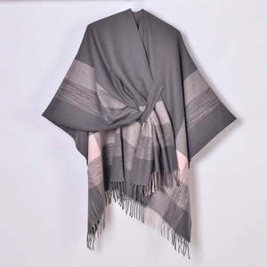 Detailed view of gray and pink plaid shawl texture with fringe and herringbone pattern