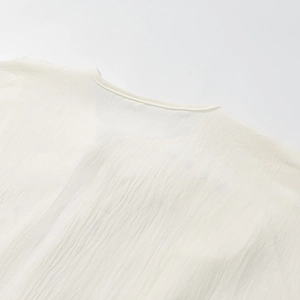 Dettaglio della trama in crepe bianco crema e bordatura del colletto su questo top