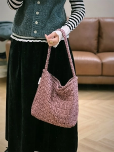 Dettaglio della borsa hobo in tweed viola con trama intrecciata ed etichetta in tessuto