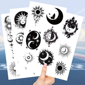 Macro view of black and white temporary tattoos featuring sun, moon and stars designs