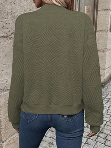 Detail of army green long sleeve jacket featuring unique quilted diamond pattern texture