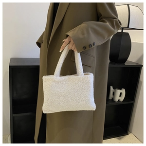Close-up of white plush teddy faux fur handbag with soft textured handles for women