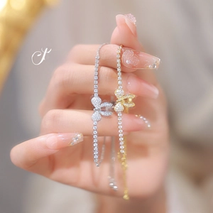 Detail showing two butterfly bracelets with sparkling zircon inlay in gold and silver finish