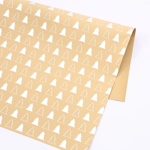 Gros plan de papier kraft brun avec motifs de sapins de Noël blancs et bord enroulé