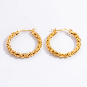 Detail of twisted 18k gold-plated stainless steel hoop earrings on white background