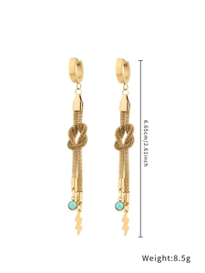 Detail shot of gold drop earrings with turquoise stones and lightning bolt pendants