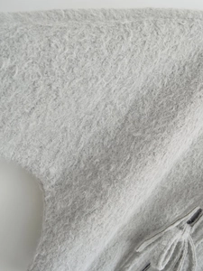 Detailopname van grijze mohair woltextuur met elegante franjes en pluizige afwerking