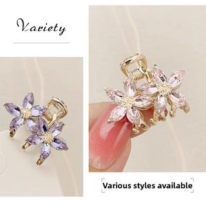 Detail of mini crystal flower hair claw clips in purple and pink with gold metal base