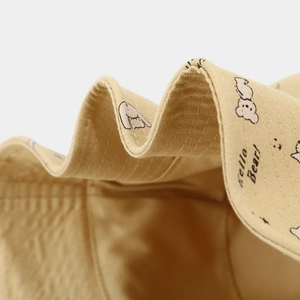 Close-up of Hello Bear print and sturdy stitching on beige sun protection bucket hat