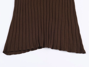 Detail of the dark brown ribbed knit fabric texture on the hemline of a stylish skirt