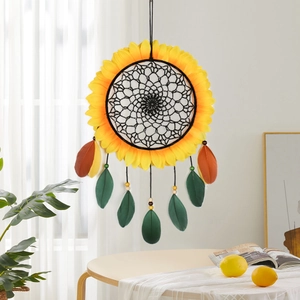 Handmade sunflower dreamcatcher with yellow petals and brown feathers hanging by a window