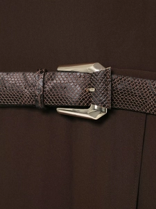 Detail of dark brown snakeskin belt with a geometric gold metal buckle on dark dress