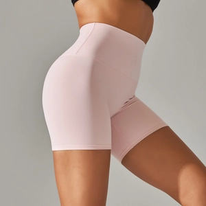 Detail view of high-waisted pale pink yoga shorts with smooth peach butt lift texture