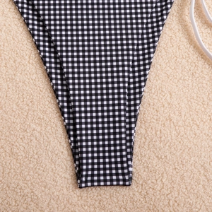 Detailed macro view of black and white gingham print high cut bikini bottoms on fur