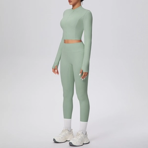 Détail de l'ensemble yoga vert sauge avec passe-pouces, haut zippé et legging taille haute